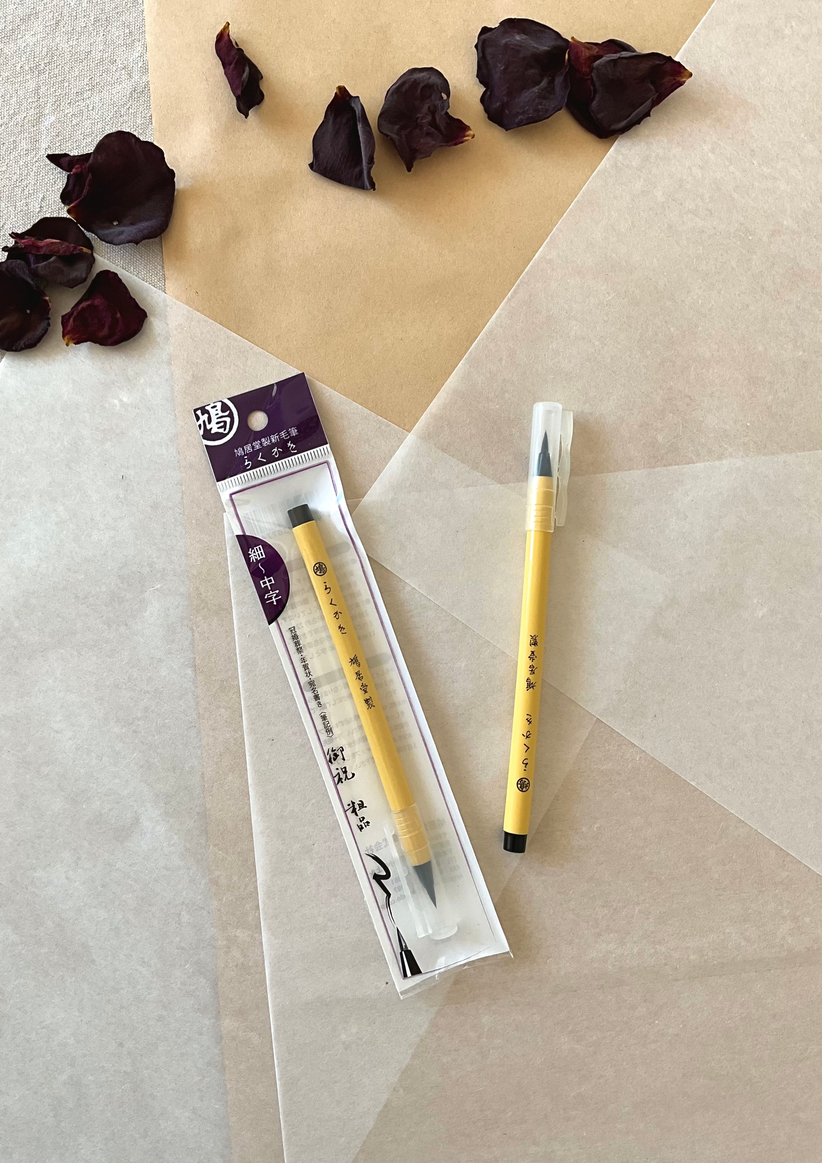 Kyukyodo Rakuka brush pen beside original packaging showing fine to medium kana calligraphy tip