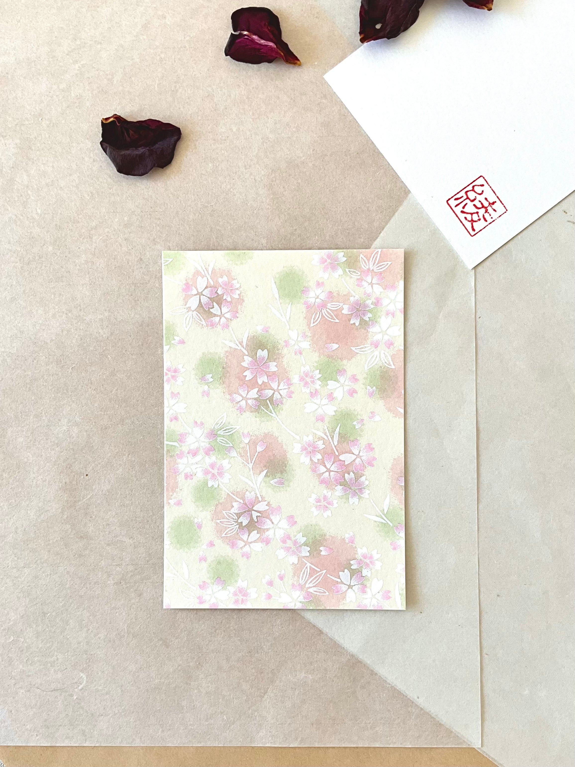 Morita Washi sakura scatter postcard showing soft white cherry blossoms with pink and green washes