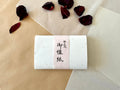 Handmade Kyoto washi paper with gold and silver leaf flecks on neutral background with dried rose petal