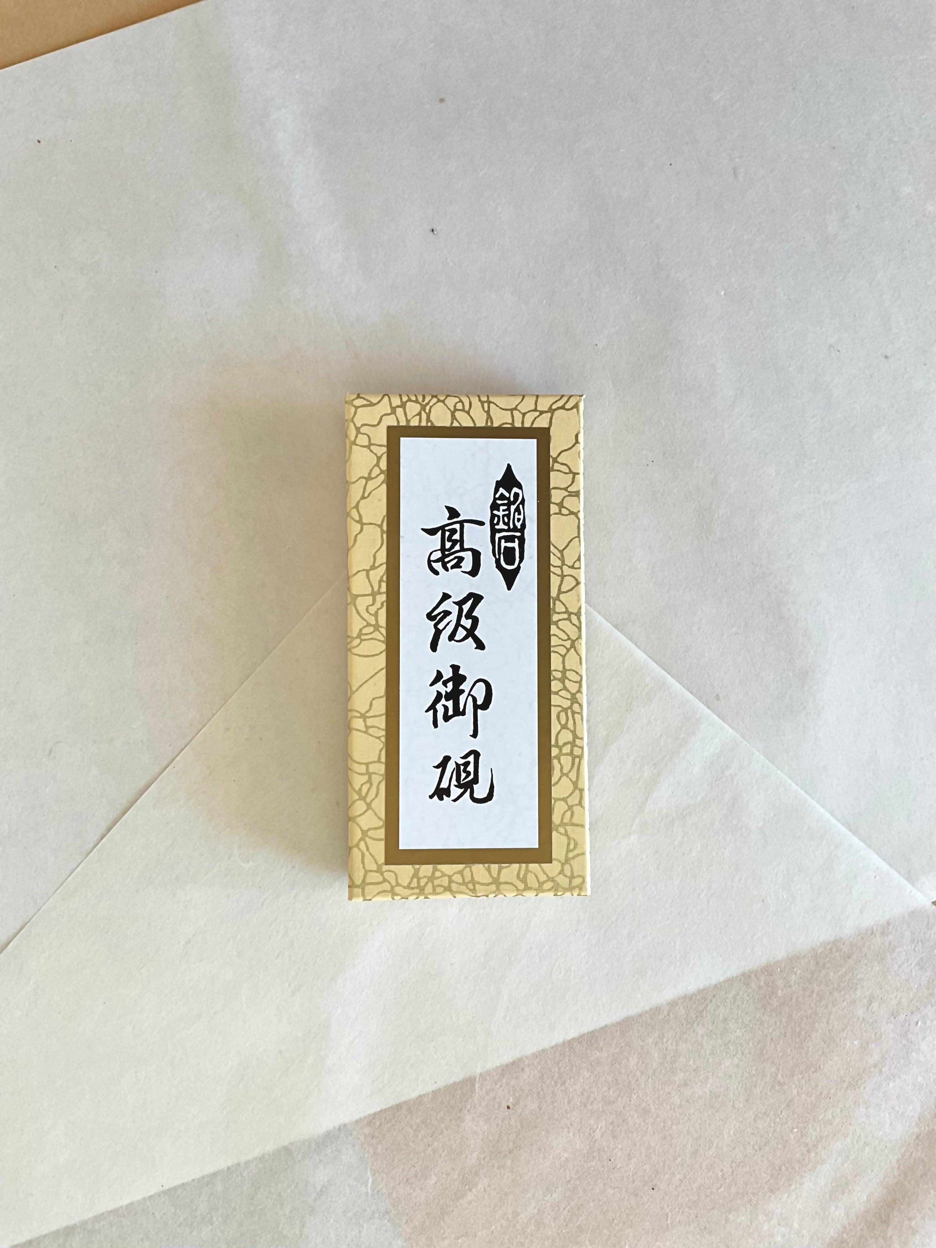 Japanese ink stone suzuri in gold crackle Kokuyo presentation box on layered washi paper