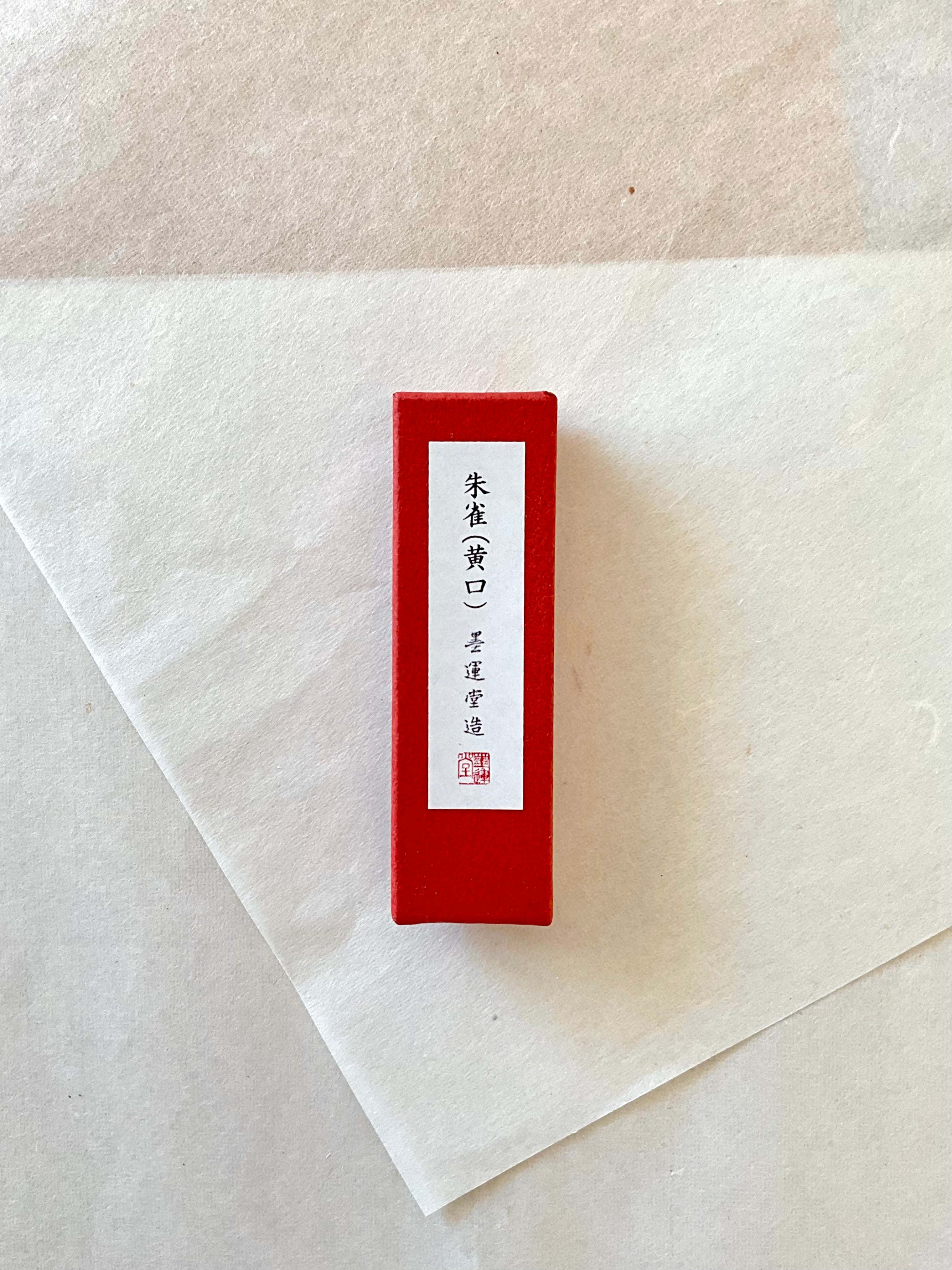 Shusai vermillion red ink stick in original presentation box on washi paper background