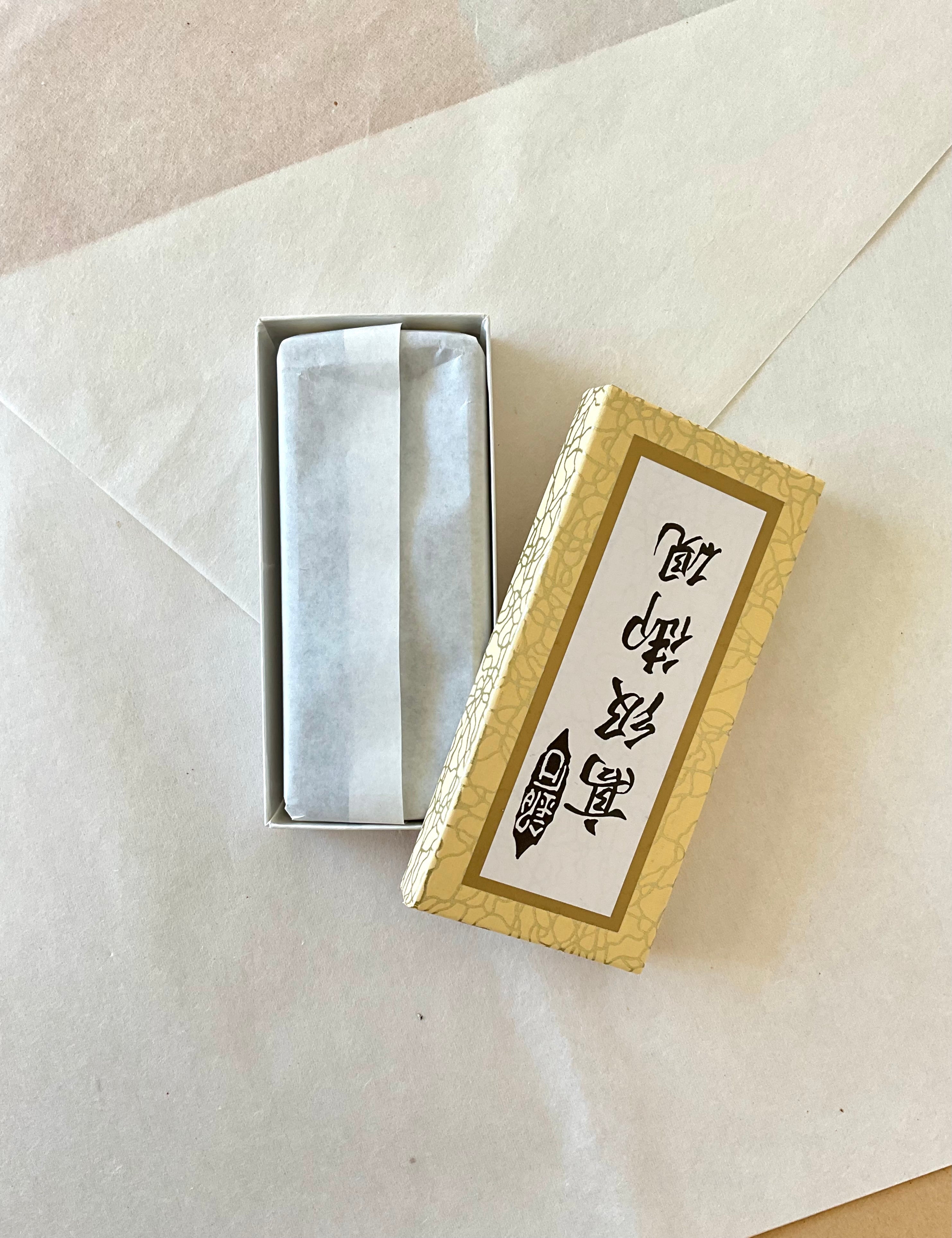 Gold crackle ink stone box open showing suzuri wrapped in washi paper inside