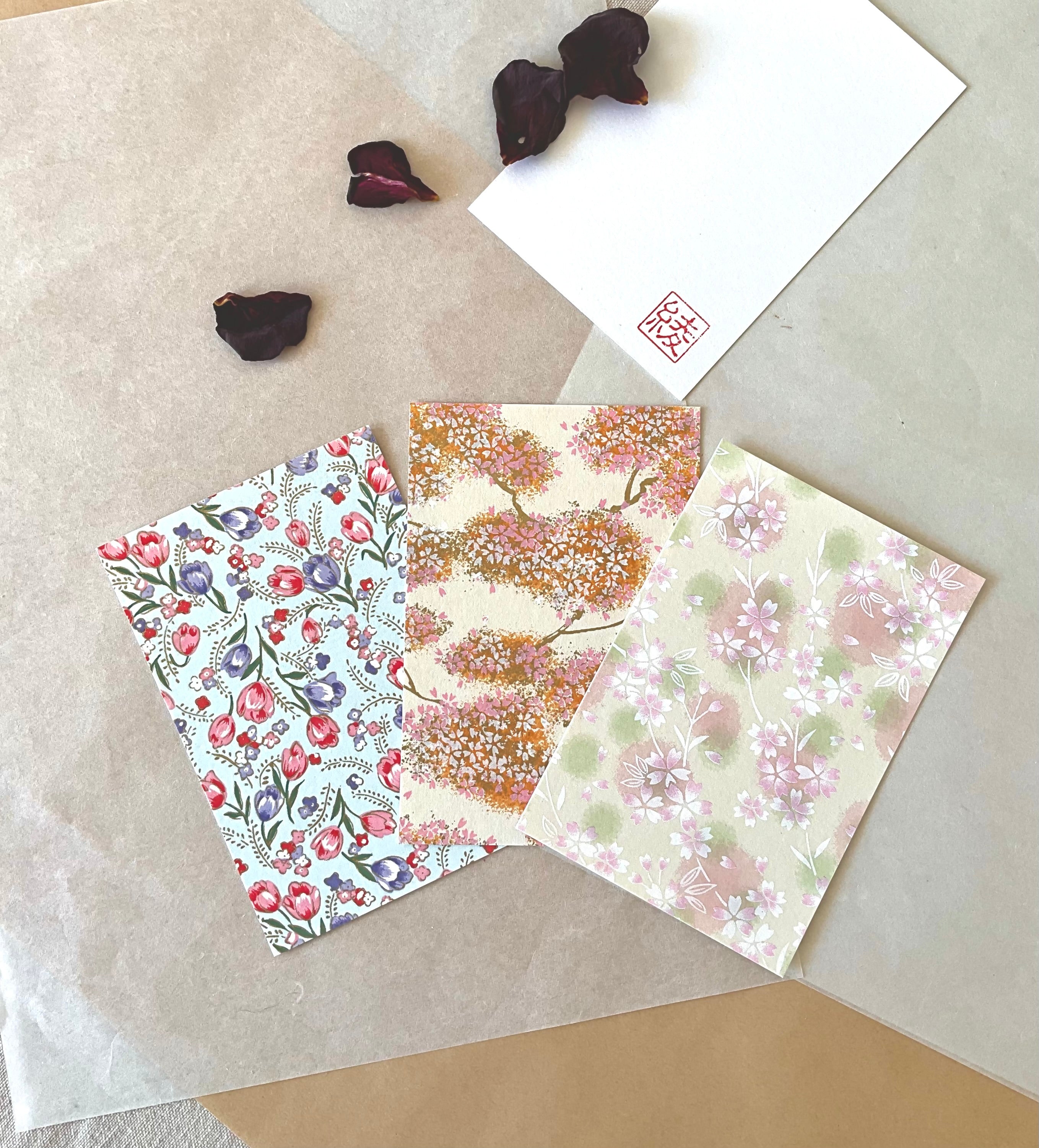 Three Morita Washi postcards fanned out showing tulip, sakura tree and sakura scatter designs on washi paper