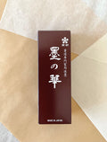 Kaimei Sumi no Hana liquid ink bottle in dark red presentation box on layered washi paper background