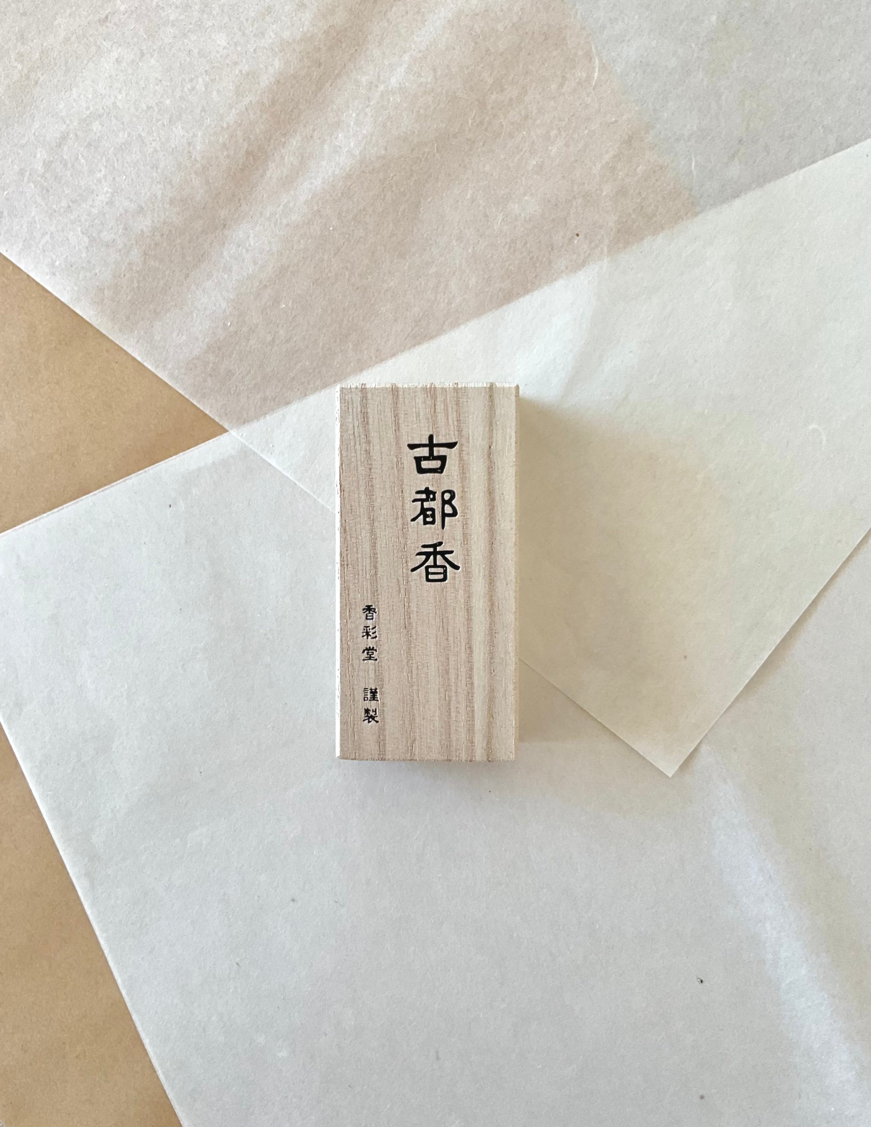 Kousaido Koto-ko Ancient Capital incense in small paulownia wood box from above on layered washi paper, Japanese kanji carved into natural pale wood grain, Kousaido maker mark below