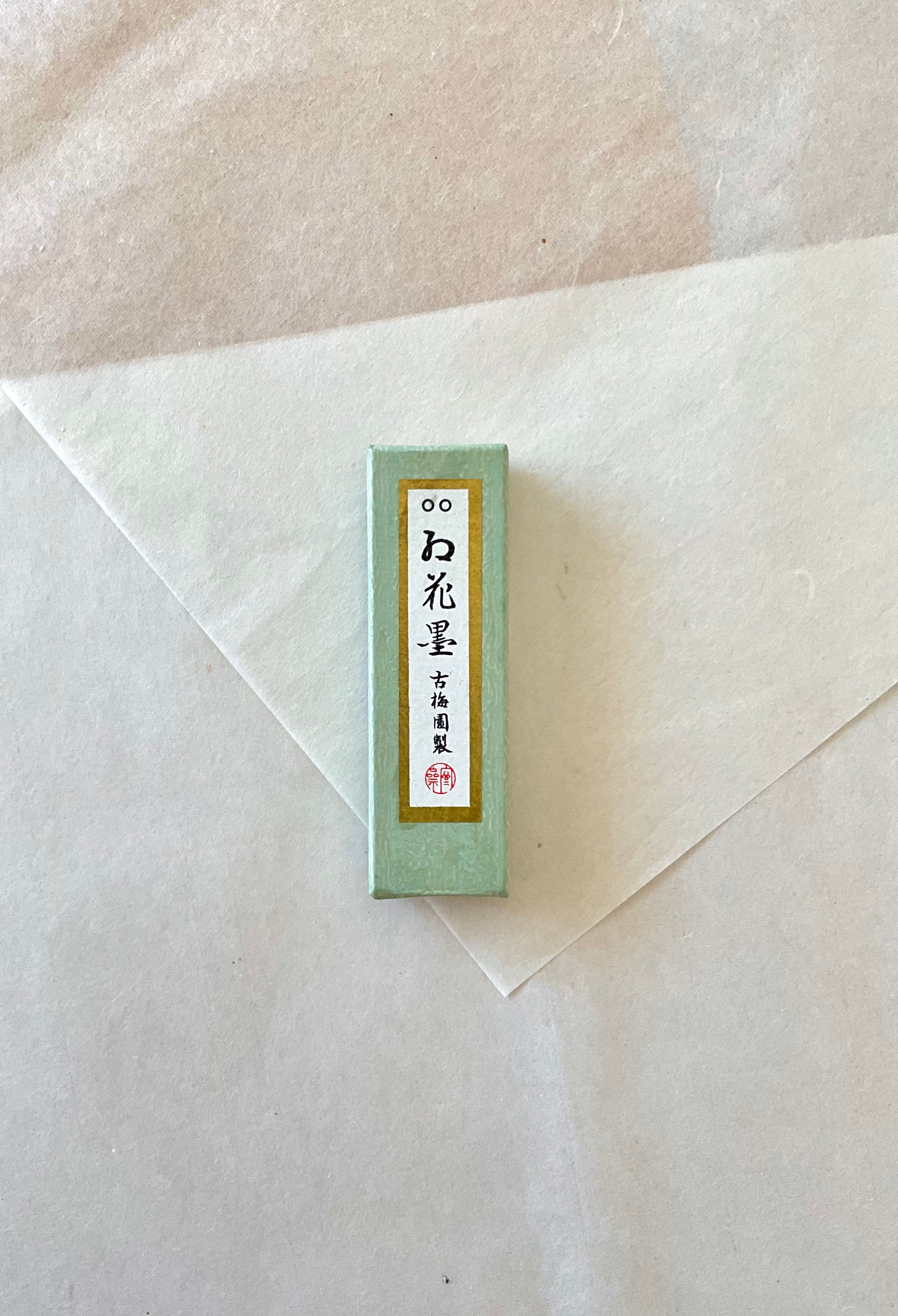Kokaun ink stick by Kobaien in green presentation box on layered washi paper background