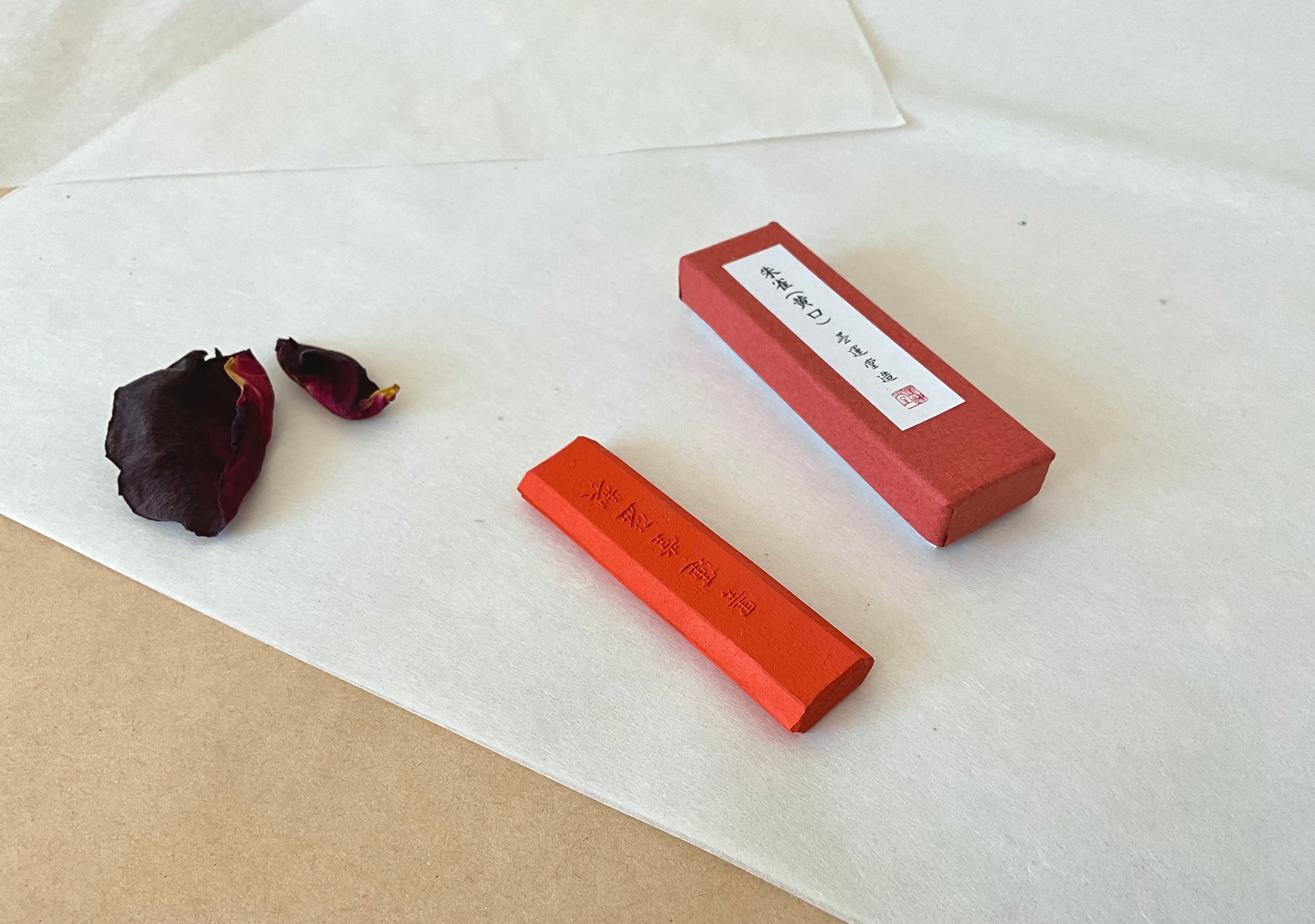 Shusai red ink stick removed from box showing engraved Japanese characters on terracotta colored stick