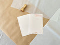 Two pink handmade Kyukyodo washi postcards on layered kraft and washi paper with hanko stamp