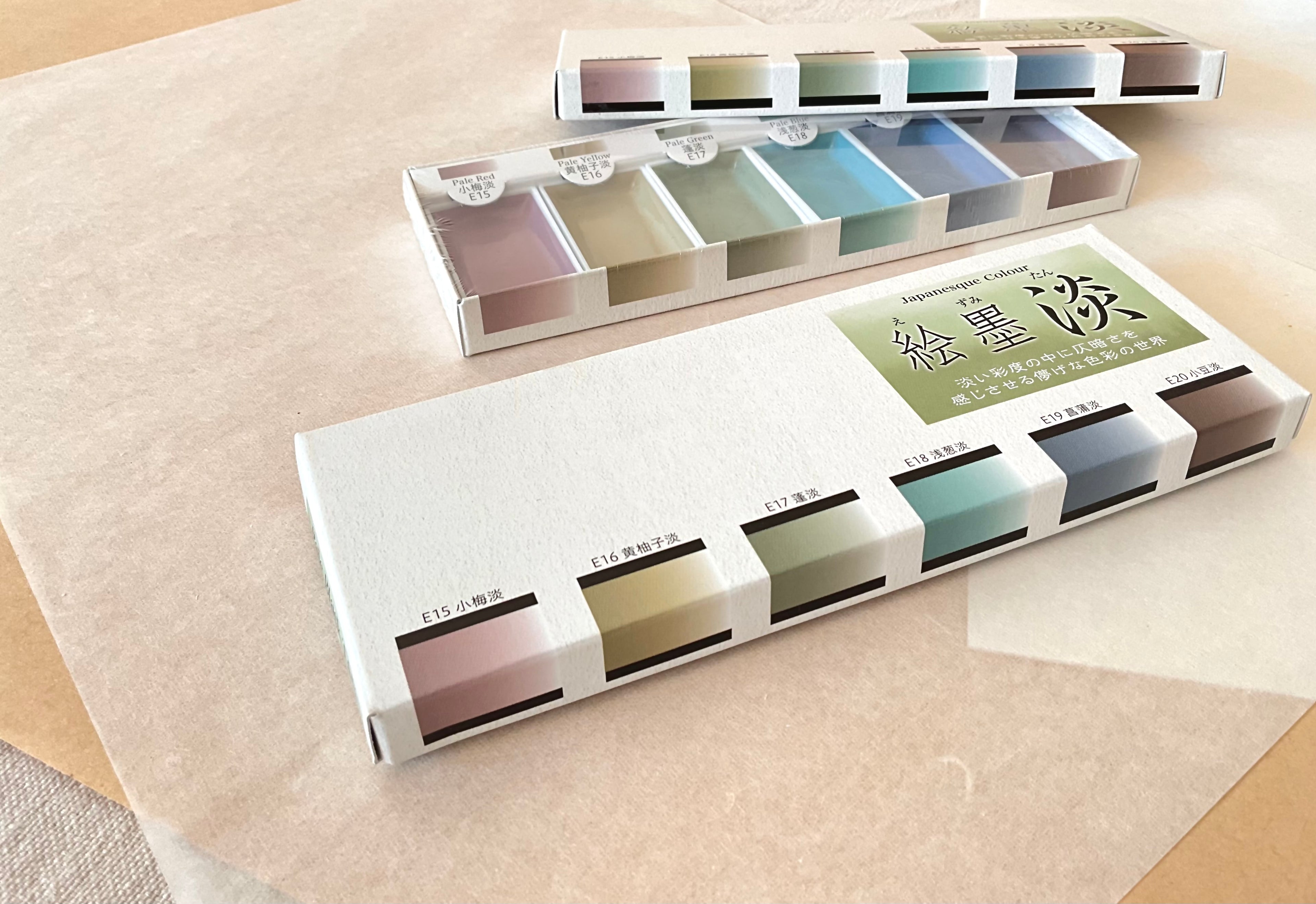 Two Ezumi Tan sets stacked open and closed showing pale color range on neutral background