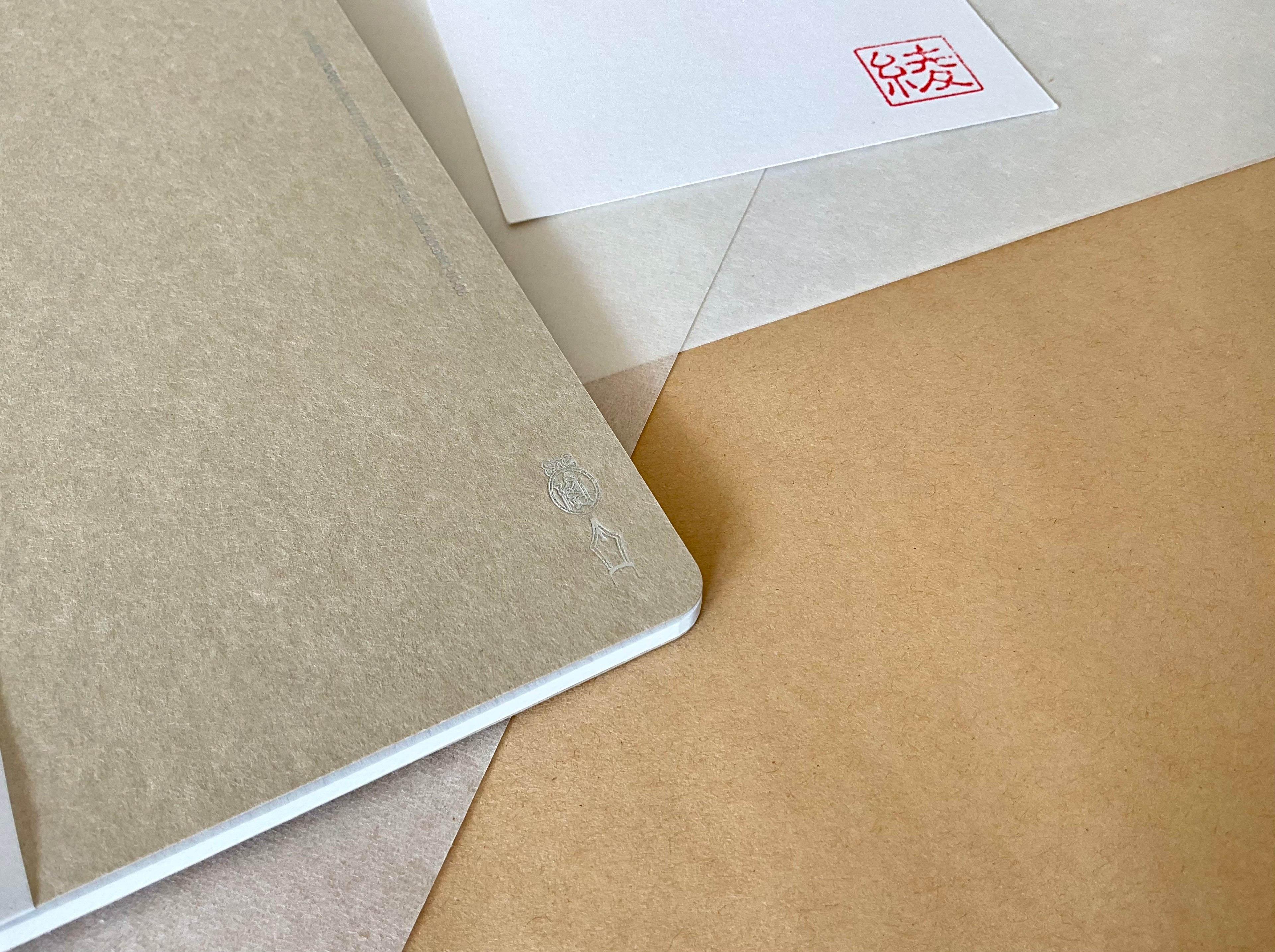 Kleid B6 beige notebook angled showing spine and cover texture on washi paper background
