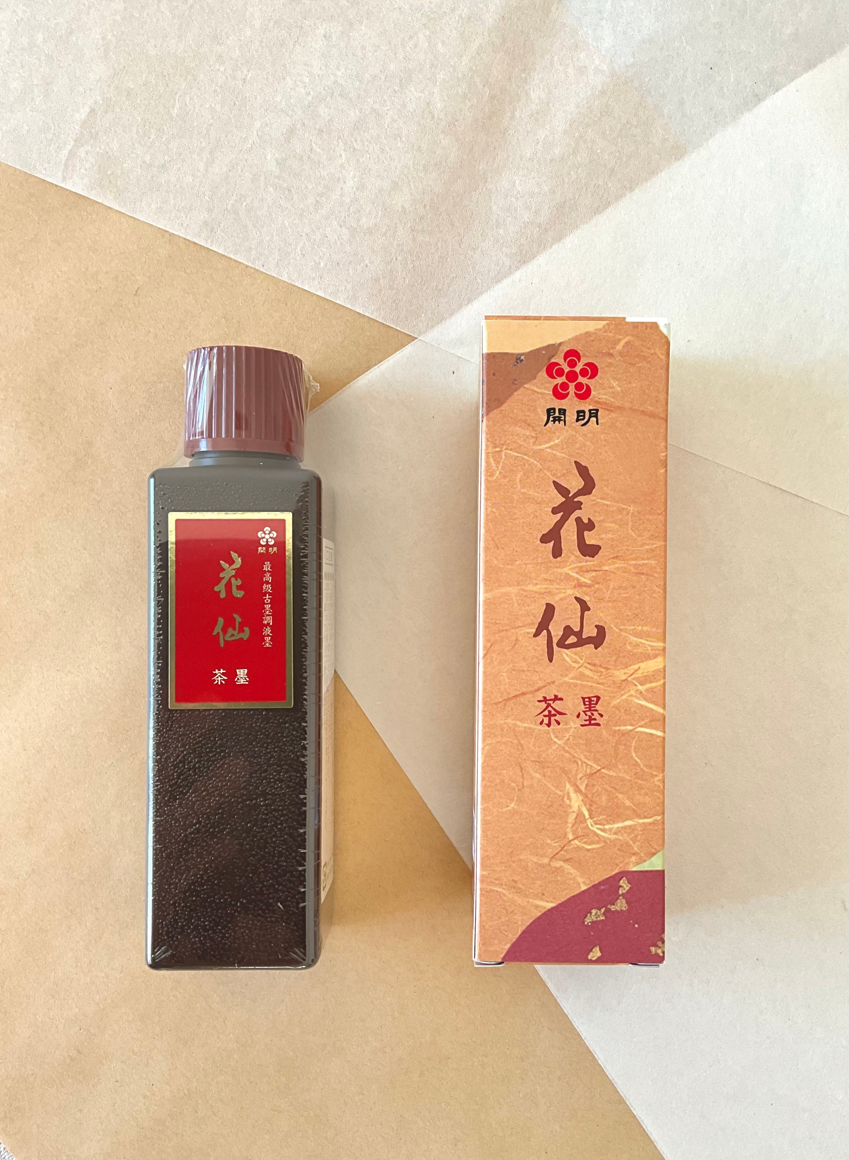Kaimei Kasen Chaboku brown-black ink bottle and box side by side on layered paper