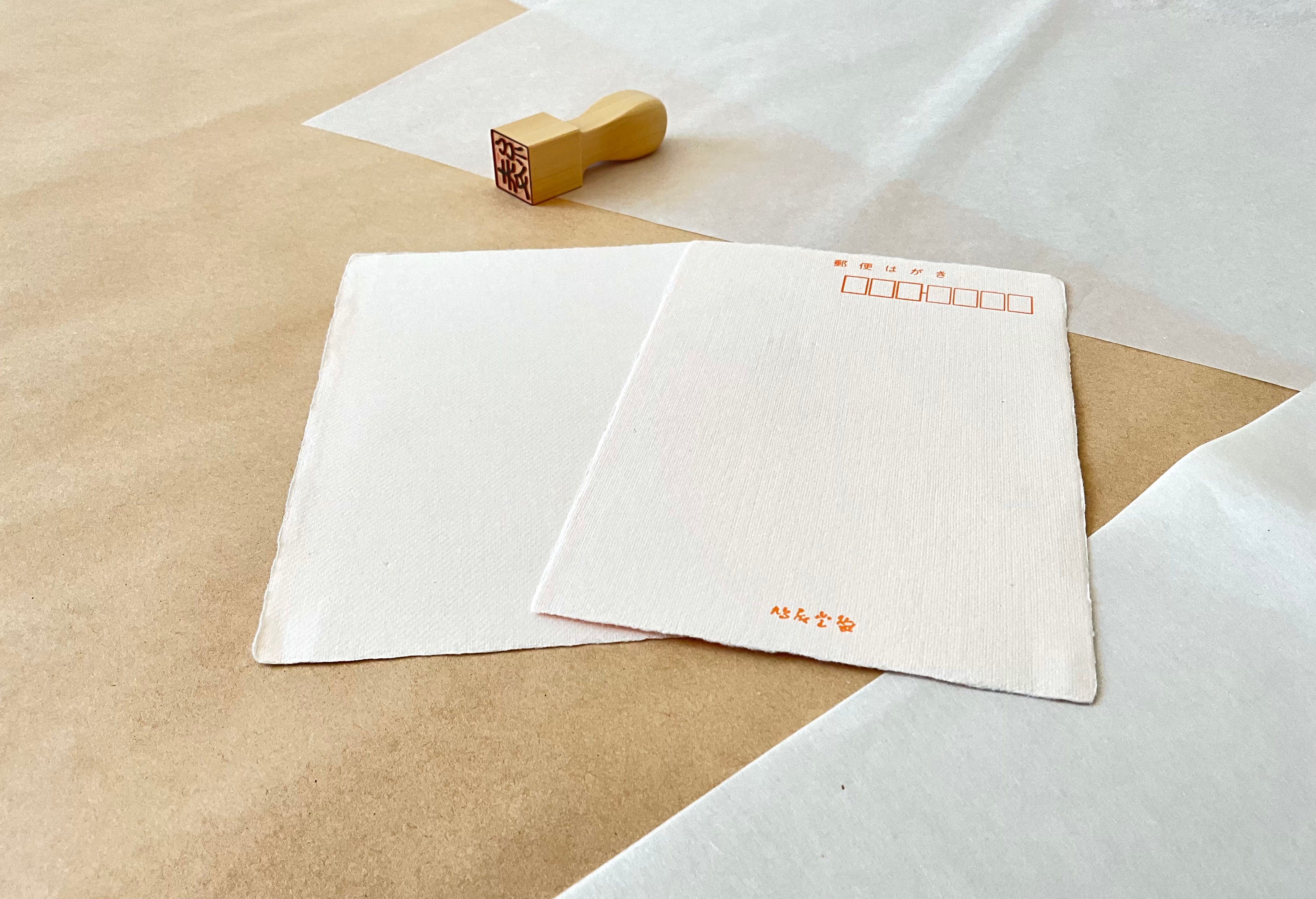 Kyukyodo pink washi postcard front and back showing deckled edges and Kyukyodo stamp beside carved wooden hanko