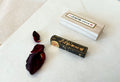 Gokaun ink stick removed from wooden box showing gold calligraphy detail on lacquered black surface