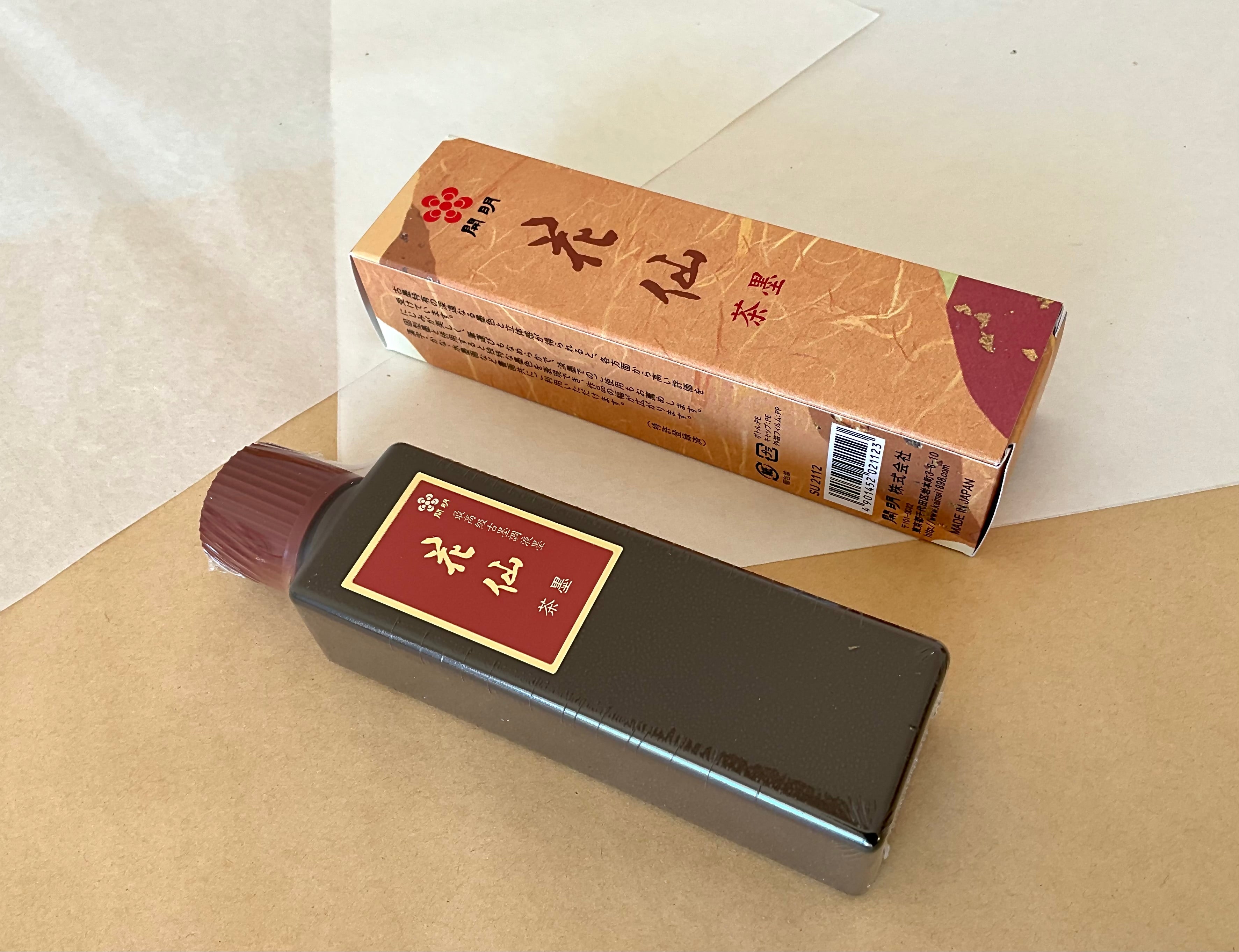 Kaimei Kasen Chaboku 100ml dark bottle beside orange presentation box on kraft paper background
